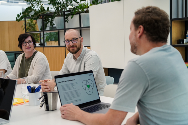 Arbeiten bei Columbus Interactive - Kollegen an einem Tisch